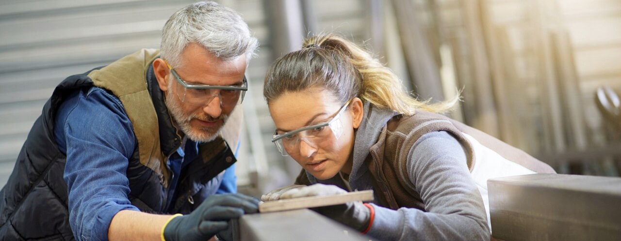 Metalworker with apprentice in workshop