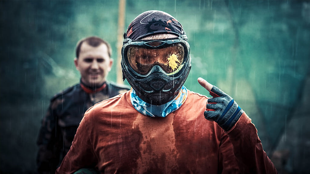 Paintball player under rain, equip for paintball